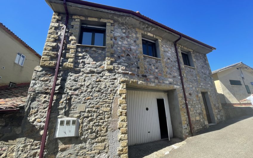 Edificio con trasteros y casa de fachada de piedra anexa en Villamanin